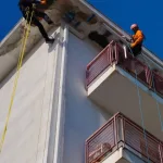 Operatori su fune durante un intervento di ristrutturazione balcone e cornicione in edilizia acrobatica