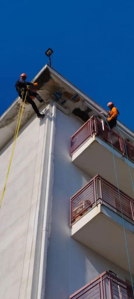 Operatori su fune durante un intervento di ristrutturazione balcone e cornicione in edilizia acrobatica